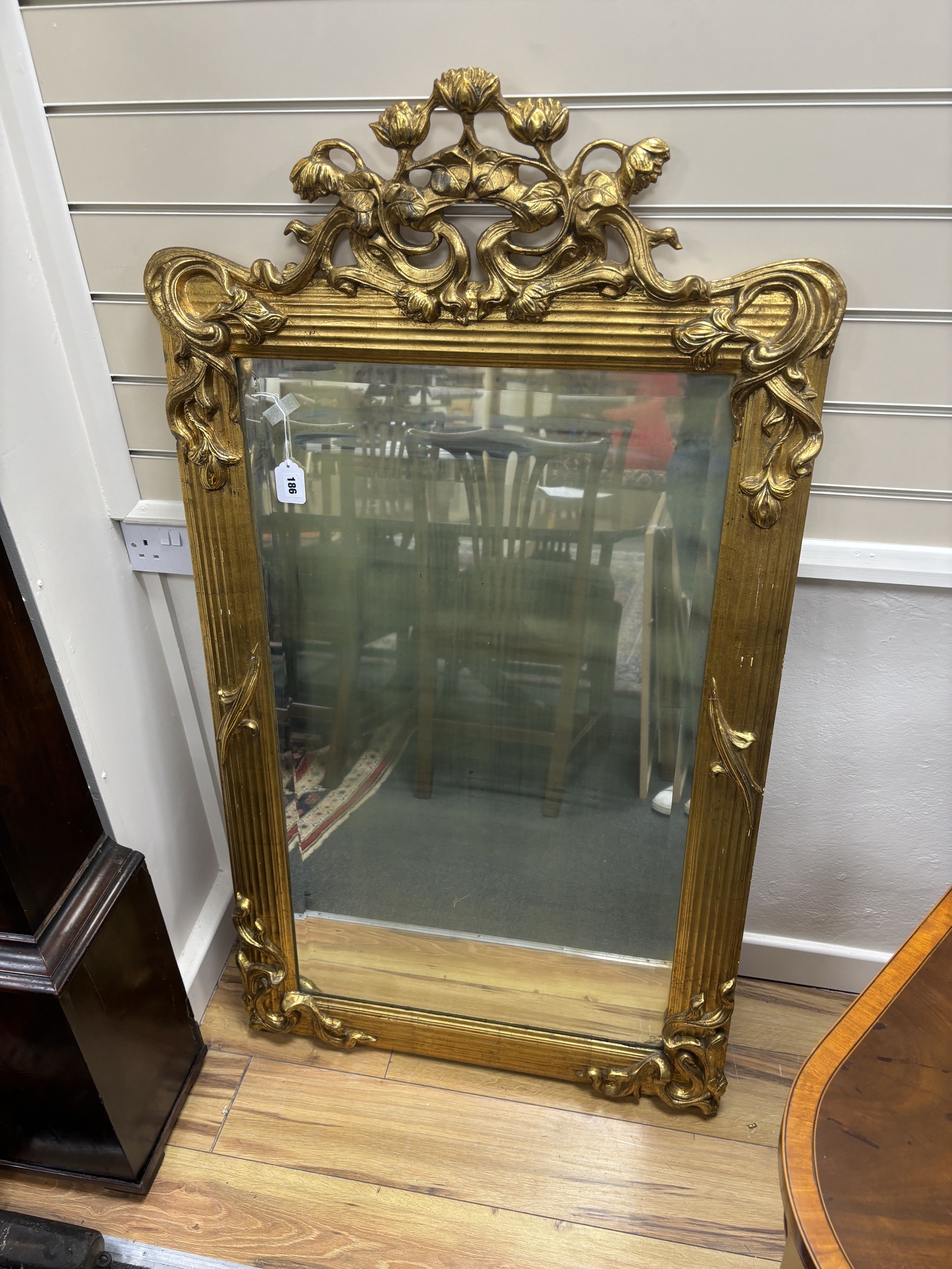 An early 20th century carved giltwood and composition wall mirror, width 78cm, height 140cm